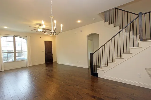 a view of a room with wooden floor fan and windows