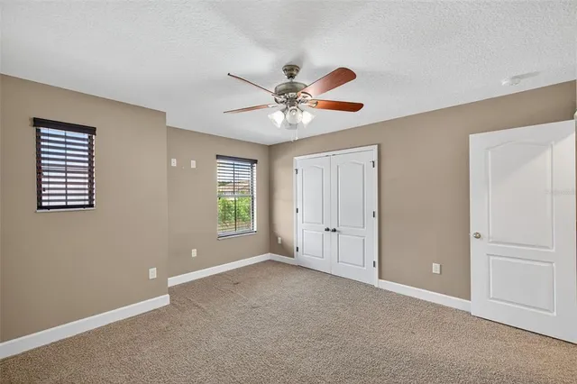 a view of an empty room with a ceiling fan