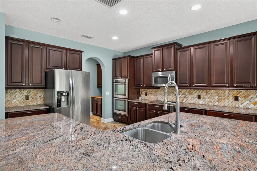 1120 Maza Place Trinity, FL 34655 - Photo 8 of 35 a kitchen with granite countertop a refrigerator and a sink