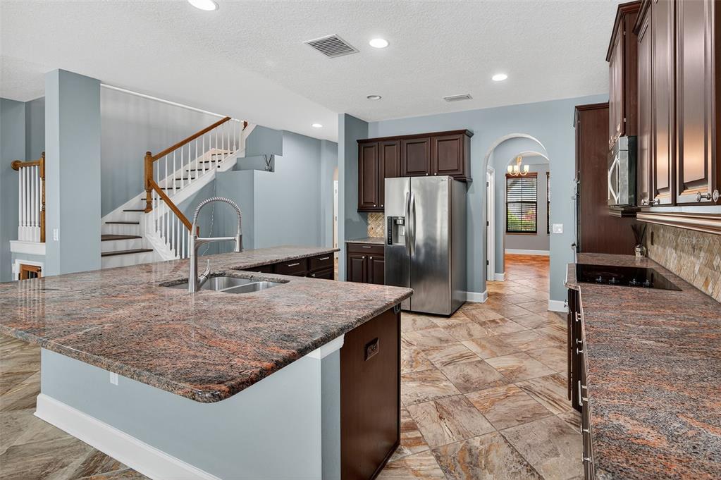 1120 Maza Place Trinity, FL 34655 - Photo 9 of 35 a kitchen with stainless steel appliances granite countertop a refrigerator a stove and a sink