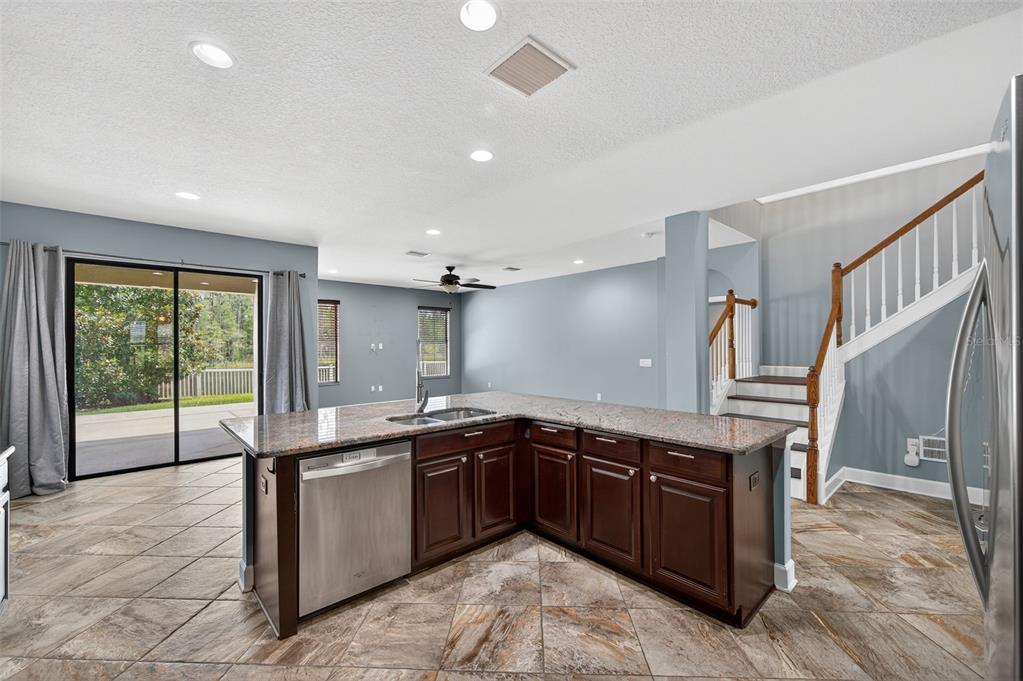 1120 Maza Place Trinity, FL 34655 - Photo 10 of 35 a large kitchen with stainless steel appliances granite countertop a sink and wooden cabinets