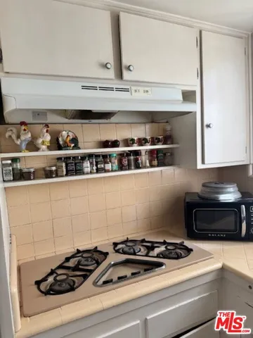 a white stove top oven sitting inside of a kitchen