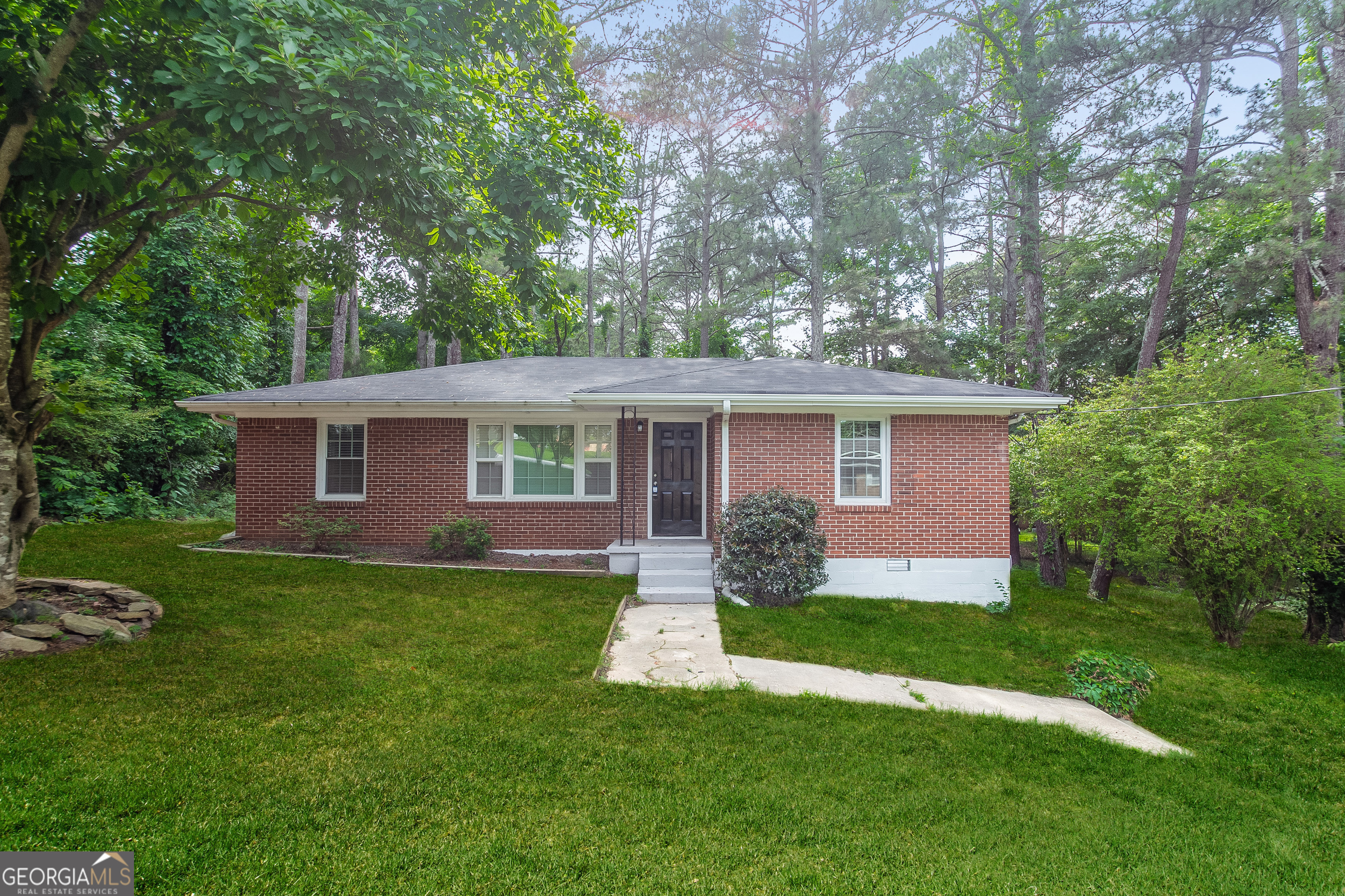 a front view of a house with a garden and yard
