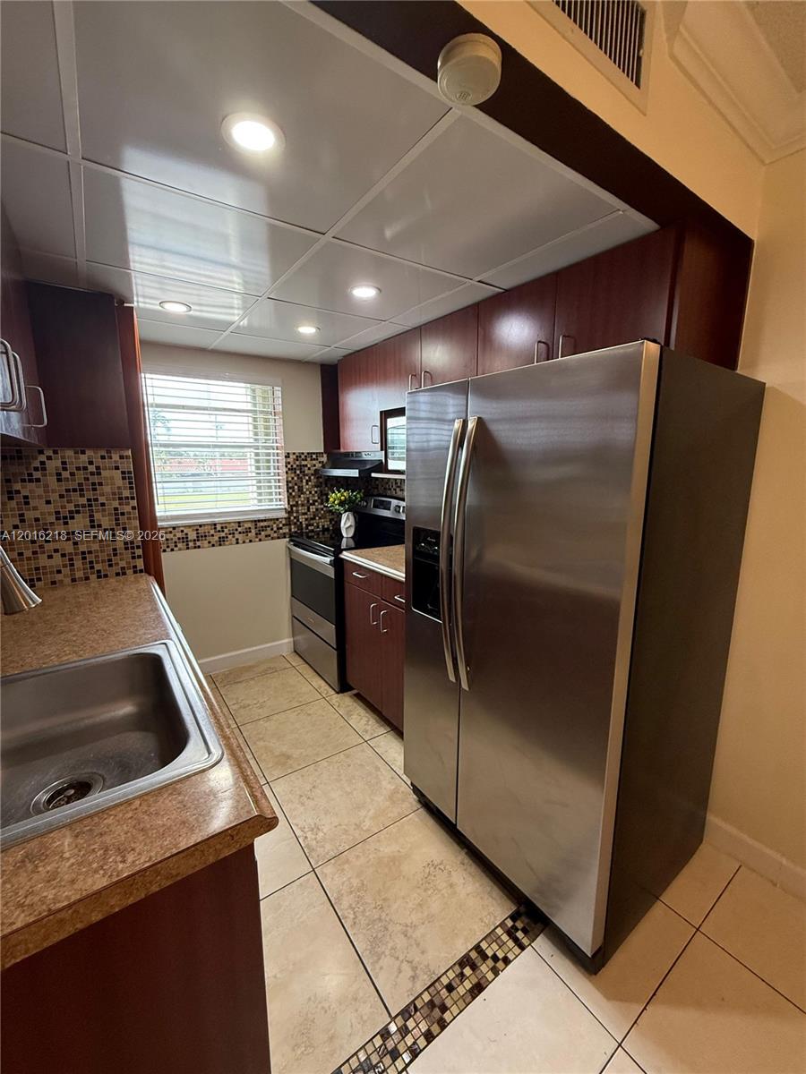 9321 Southwest 4th Street, Unit 230C Miami, FL 33174 - Photo 16 of 37 a kitchen with granite countertop a refrigerator and a sink