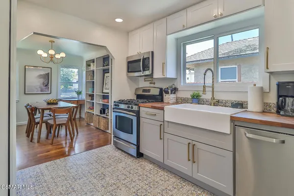 a kitchen with cabinets appliances and a dining table