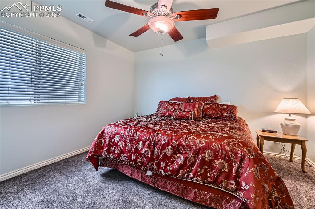 2553 Cinnabar Road Colorado Springs, CO 80921 - Photo 23 of 27 a bedroom with a bed and a chandelier