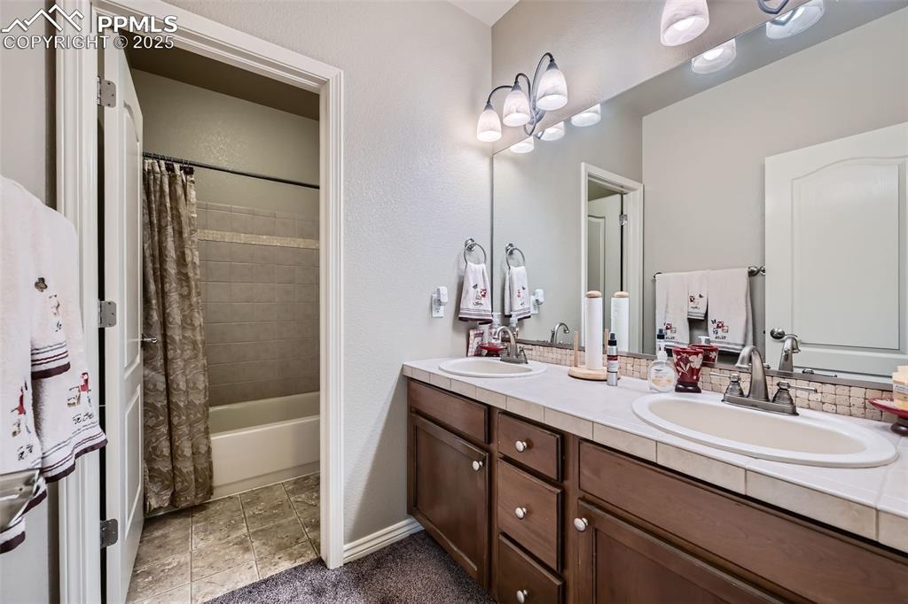 2553 Cinnabar Road Colorado Springs, CO 80921 - Photo 24 of 27 a bathroom with a double vanity sink mirror and shower
