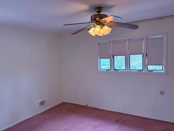an empty room with windows and wooden floor