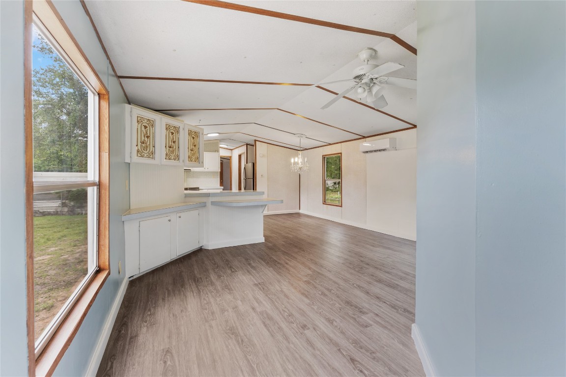 21504 Mexican John Road, Unit C New Caney, TX 77357 - Photo 12 of 15 a view of a big room with wooden floor windows and chandelier