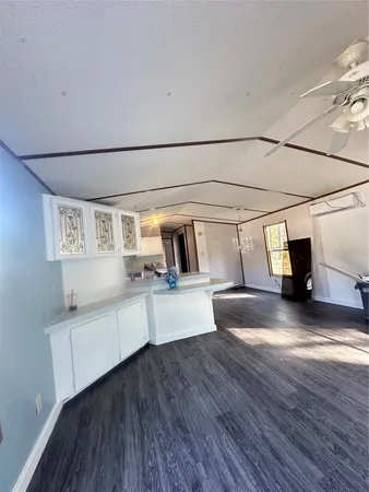 a kitchen with kitchen island a stove a sink wooden floor and cabinets