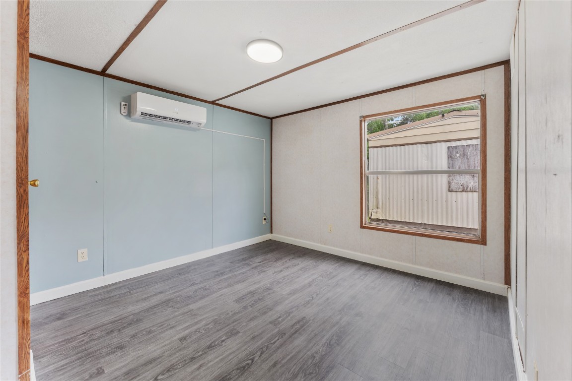 21504 Mexican John Road, Unit C New Caney, TX 77357 - Photo 10 of 15 an empty room with wooden floor and windows