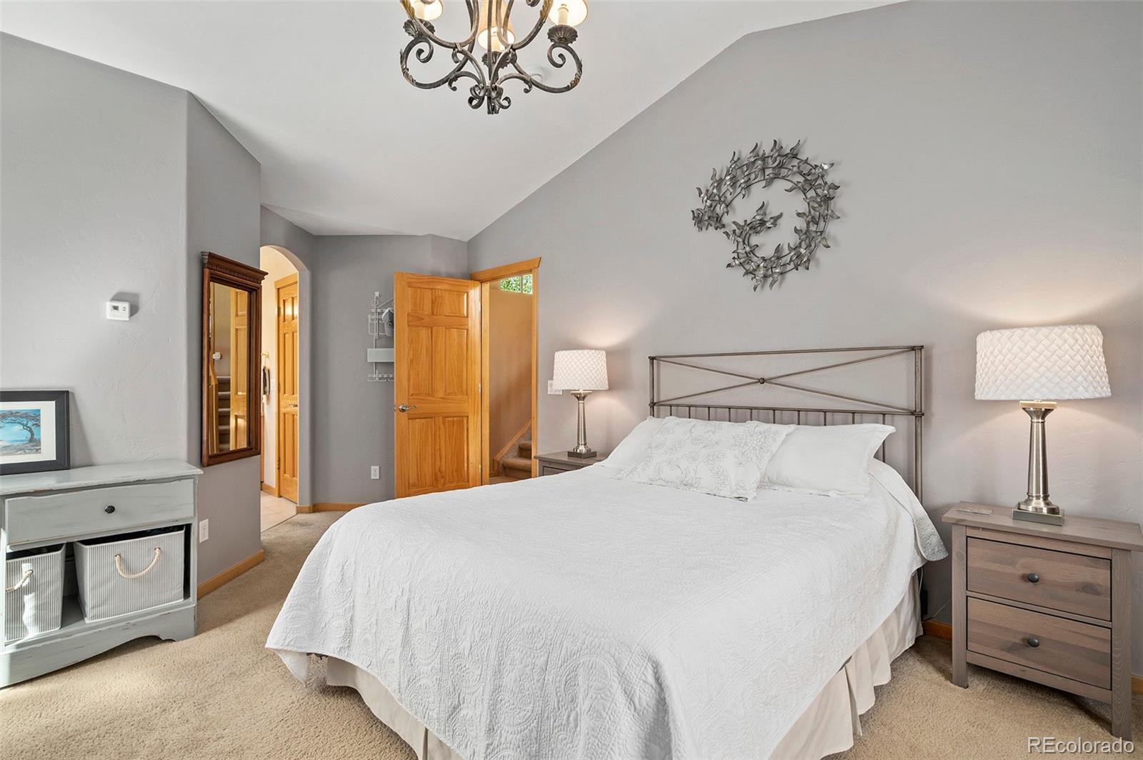 290 Village Road Granby, CO 80446 - Photo 17 of 45 a bedroom with a bed and a chandelier