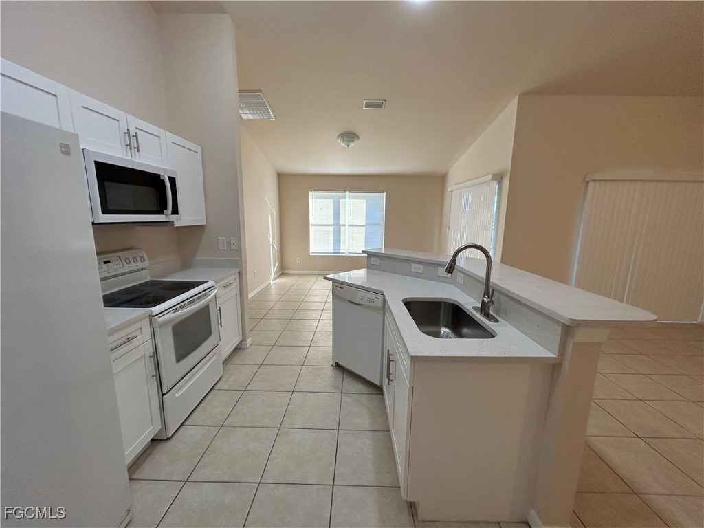 3719 32nd Street Southwest Lehigh Acres, FL 33976 - Photo 6 of 15 a kitchen with a sink a stove and microwave