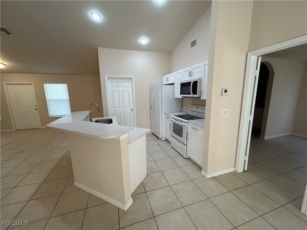 3719 32nd Street Southwest Lehigh Acres, FL 33976 - Photo 7 of 15 a kitchen with stainless steel appliances a refrigerator and a stove