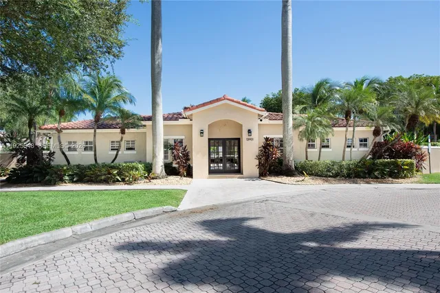 a front view of a house with a garden and trees