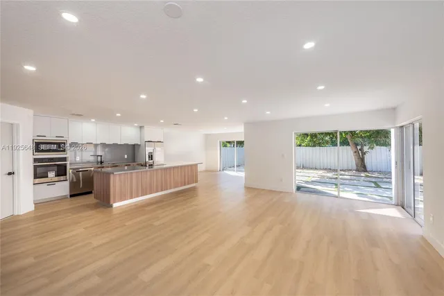 a kitchen with stainless steel appliances kitchen island granite countertop a stove a sink and a refrigerator