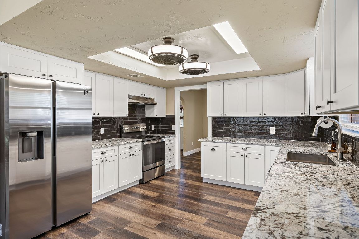 4203 Azul Court Georgetown, TX 78628 - Photo 20 of 38 a kitchen with granite countertop a refrigerator stove top oven and sink