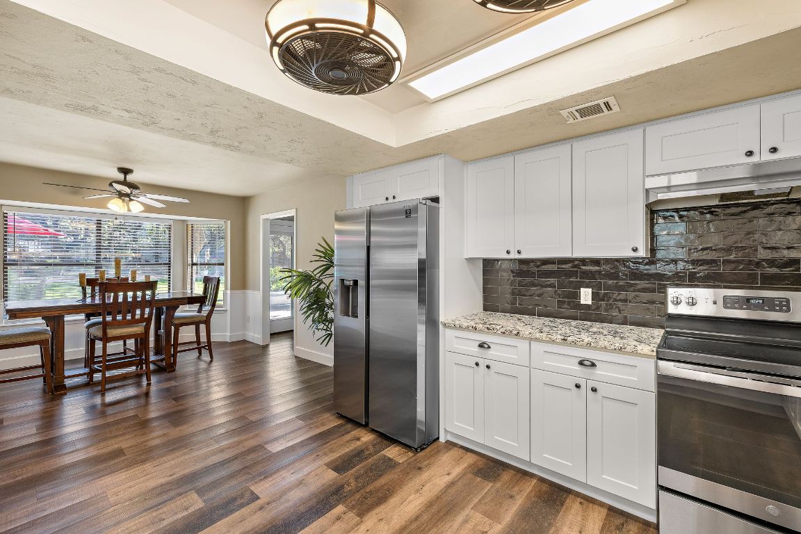 4203 Azul Court Georgetown, TX 78628 - Photo 21 of 38 a kitchen with stainless steel appliances a dining table chairs stove and cabinets