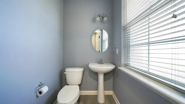 a bathroom with a toilet sink and mirror