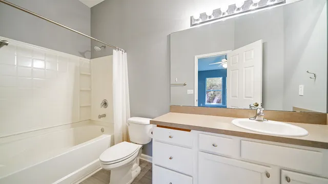 a bathroom with a sink a toilet and a large mirror