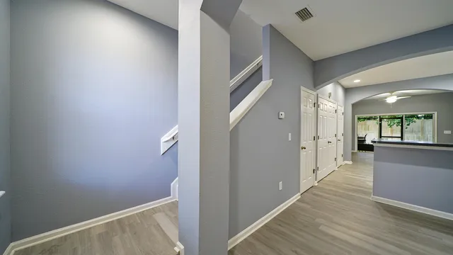 a view of a hallway with wooden floor and staircase