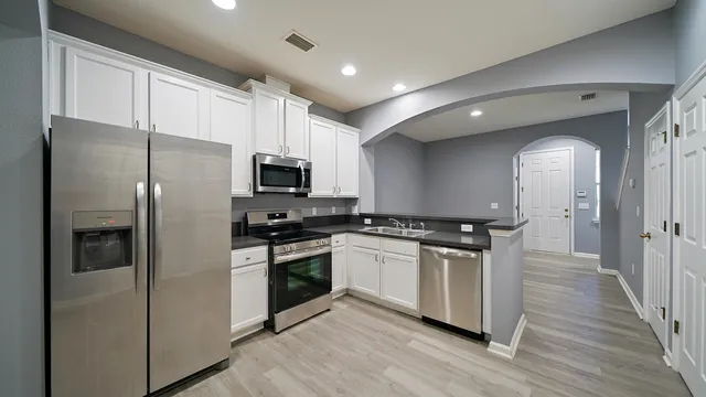 a kitchen with stainless steel appliances granite countertop a stove a refrigerator and a microwave