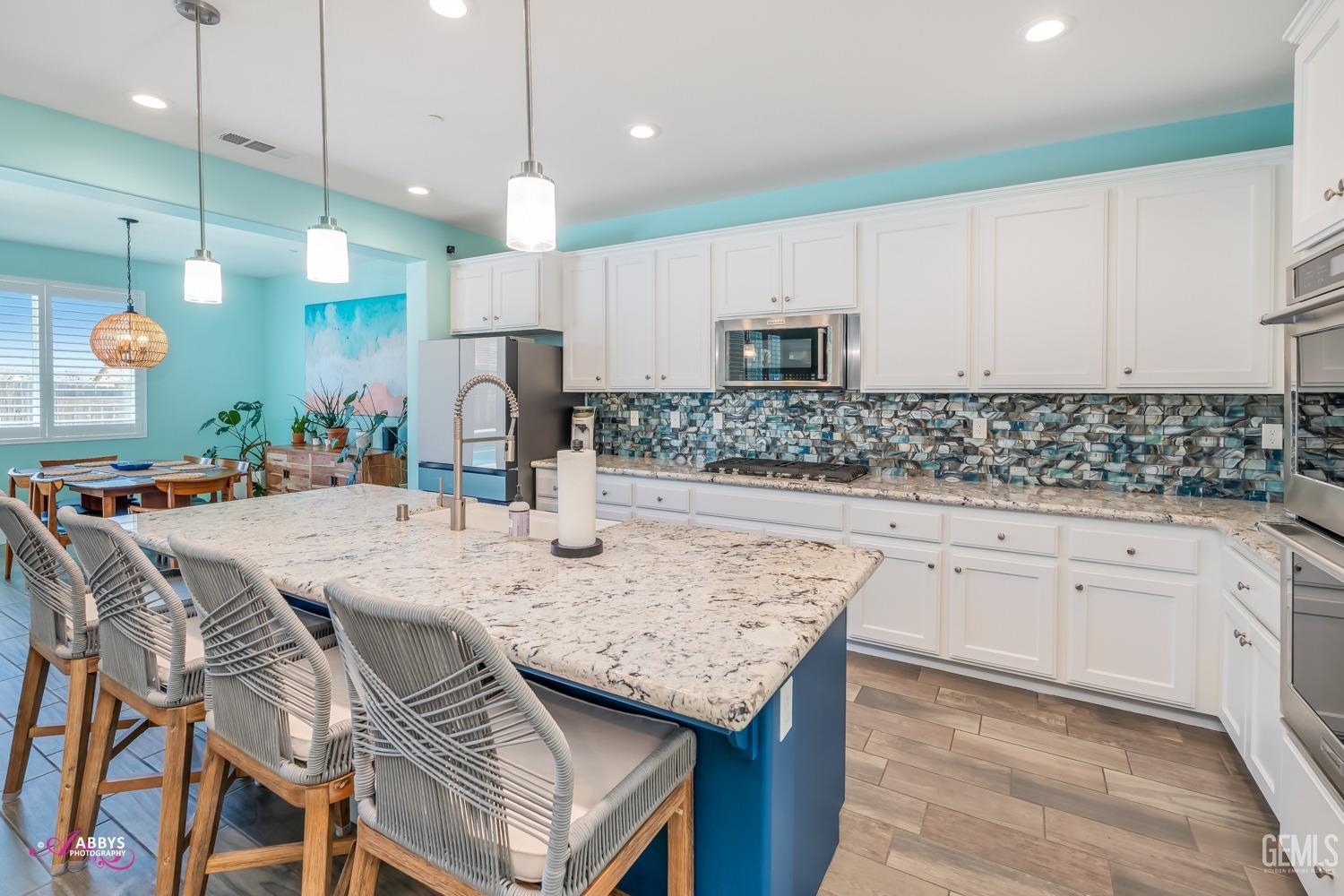 Undisclosed Address Bakersfield, CA 93314 - Photo 16 of 40 a kitchen with stainless steel appliances kitchen island granite countertop a sink a stove a refrigerator and cabinets