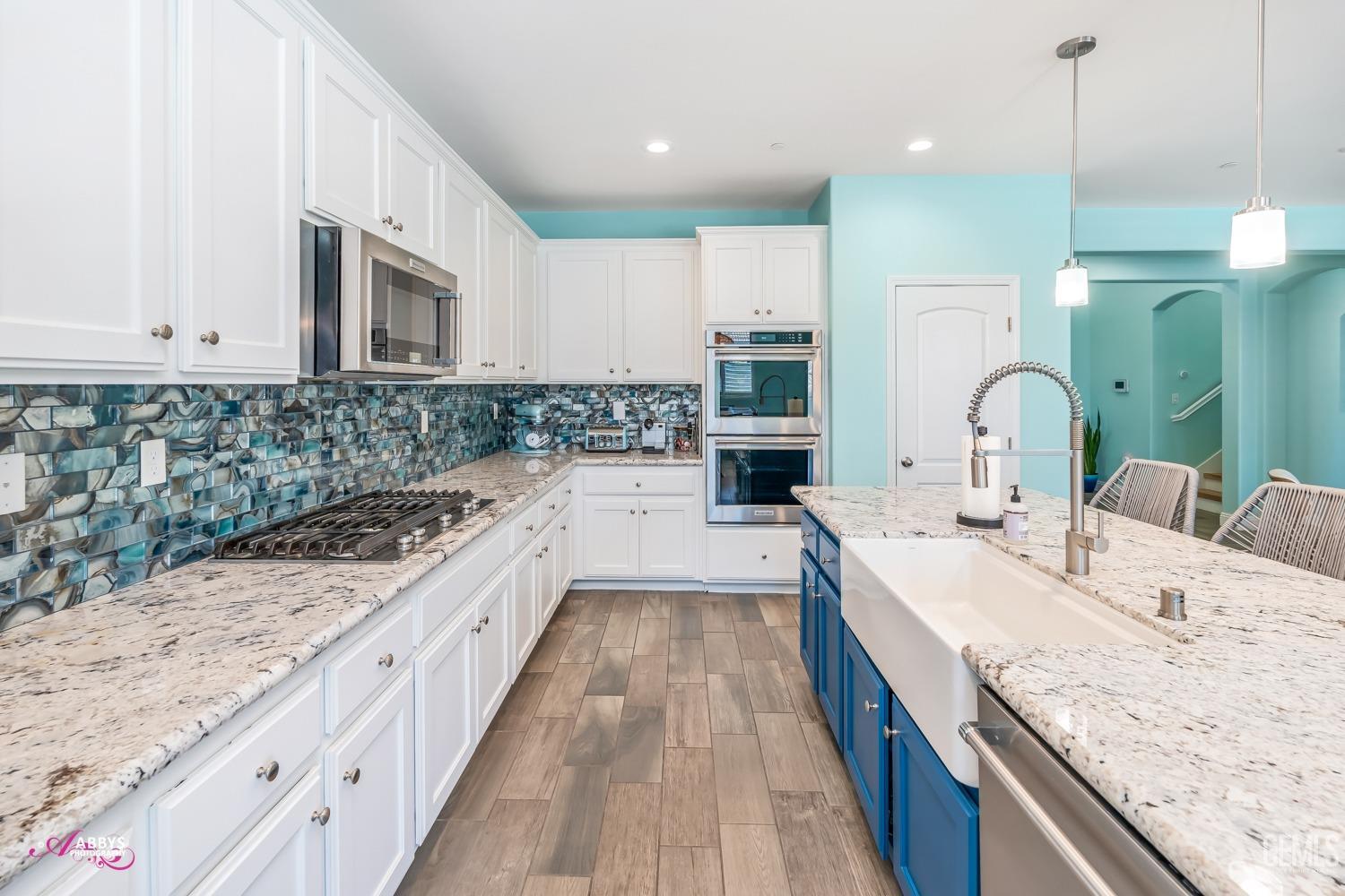 Undisclosed Address Bakersfield, CA 93314 - Photo 17 of 40 a large kitchen with kitchen island a large counter space a sink stainless steel appliances and cabinets