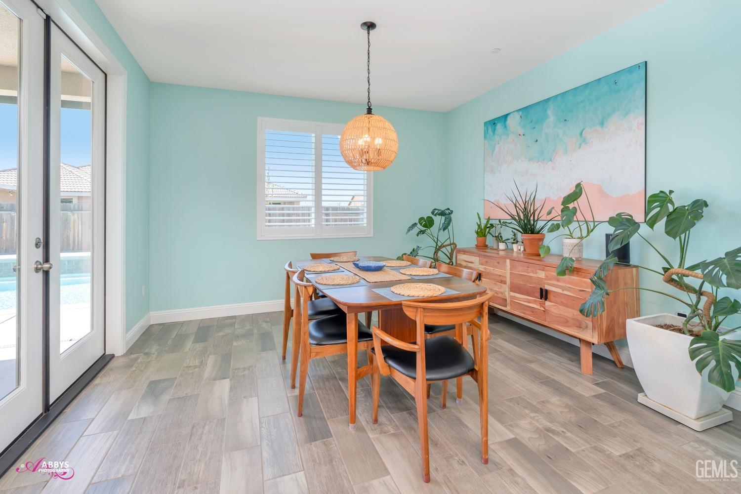 Undisclosed Address Bakersfield, CA 93314 - Photo 21 of 40 a dining room with furniture potted plants and wooden floor