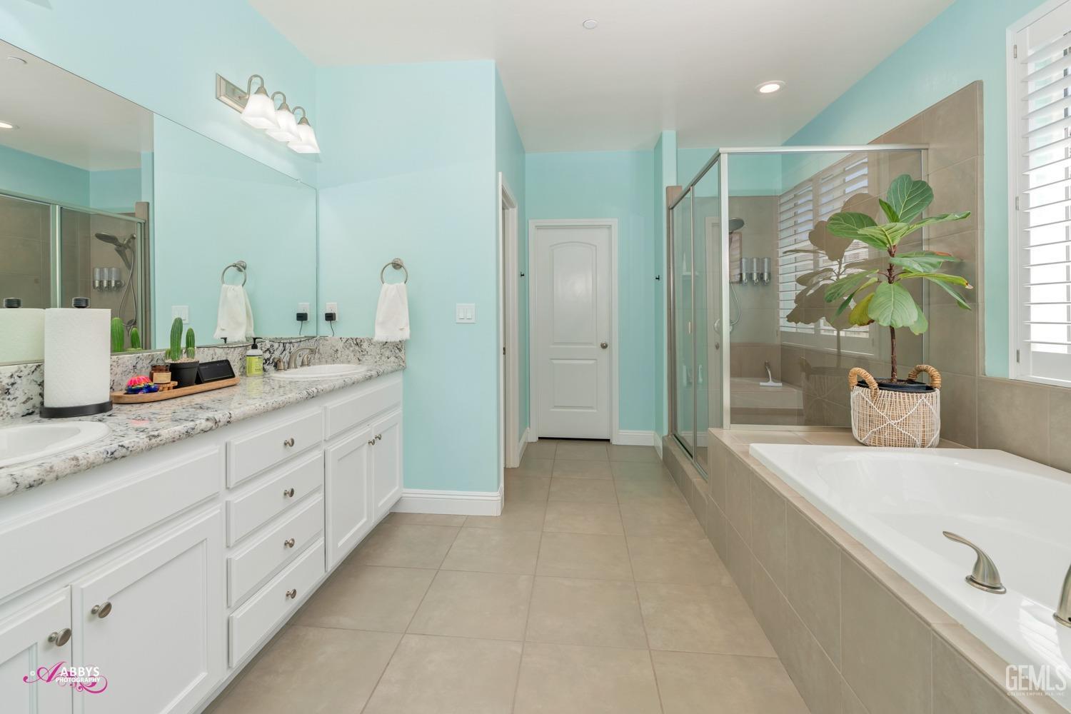 Undisclosed Address Bakersfield, CA 93314 - Photo 23 of 40 a spacious bathroom with a granite countertop sink a mirror a bathtub and next to a window