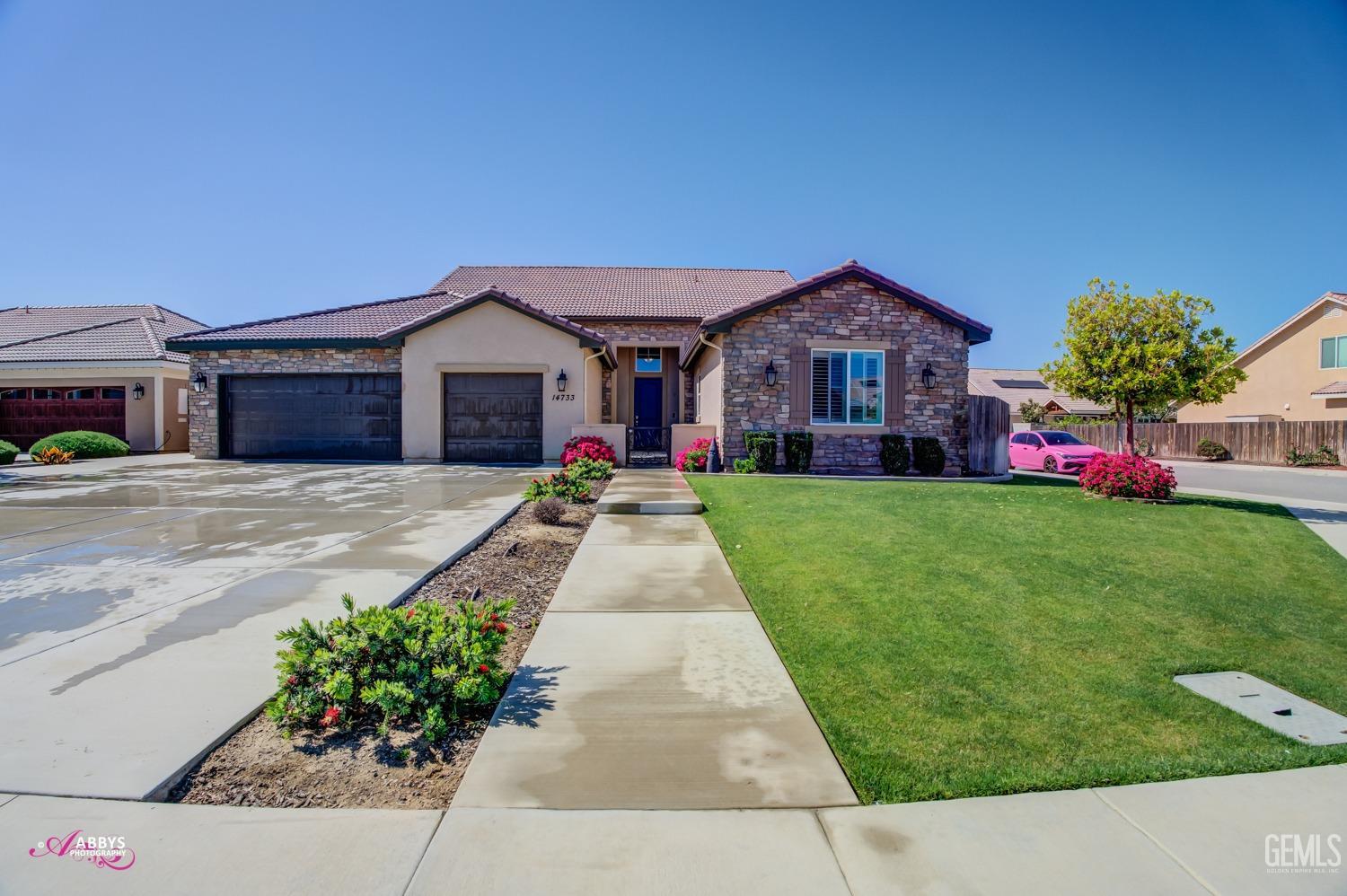 Undisclosed Address Bakersfield, CA 93314 - Photo 5 of 40 a front view of a house with a yard and potted plants