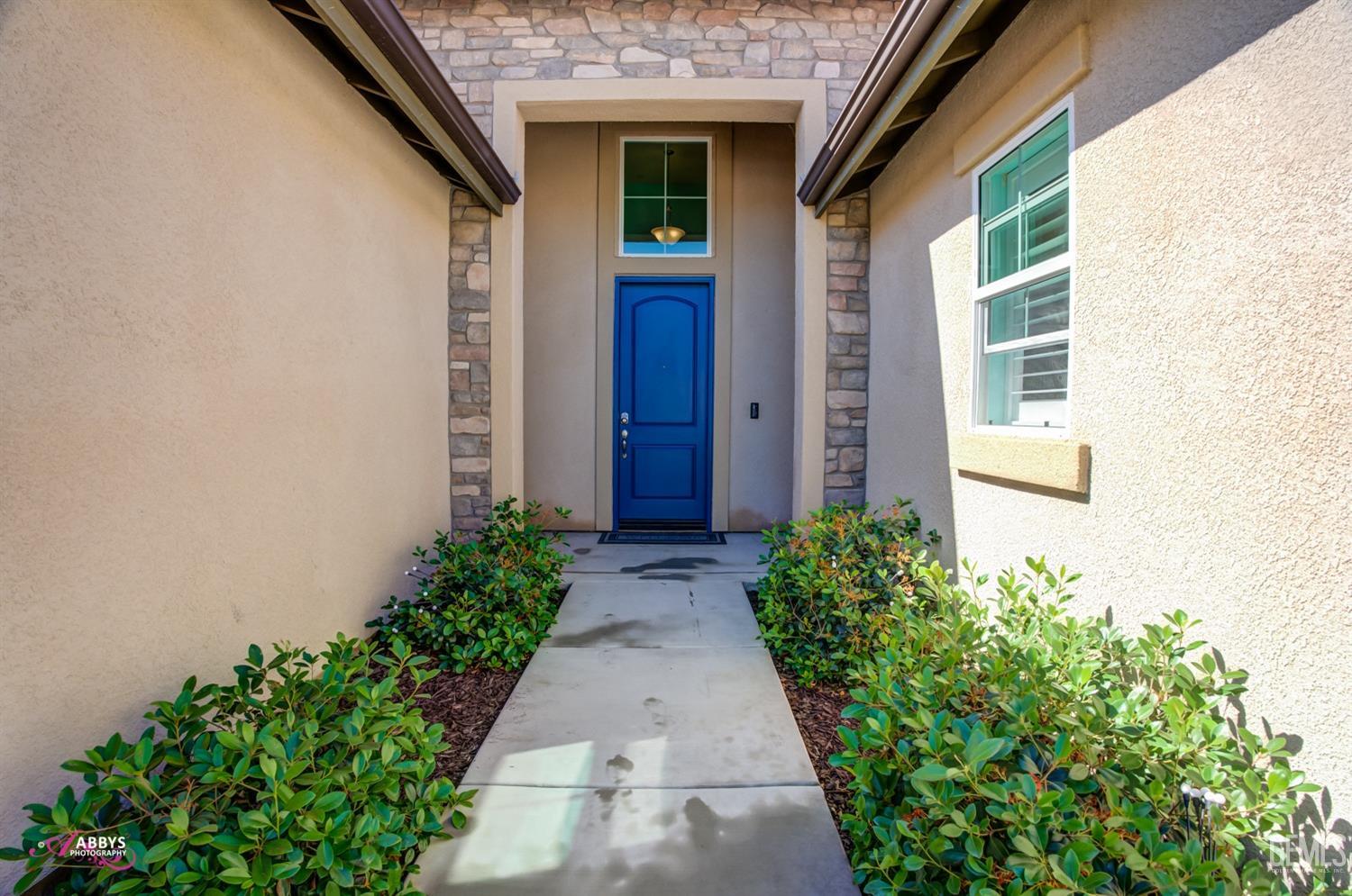 Undisclosed Address Bakersfield, CA 93314 - Photo 8 of 40 a view of a pathway door with flower plants in front of door