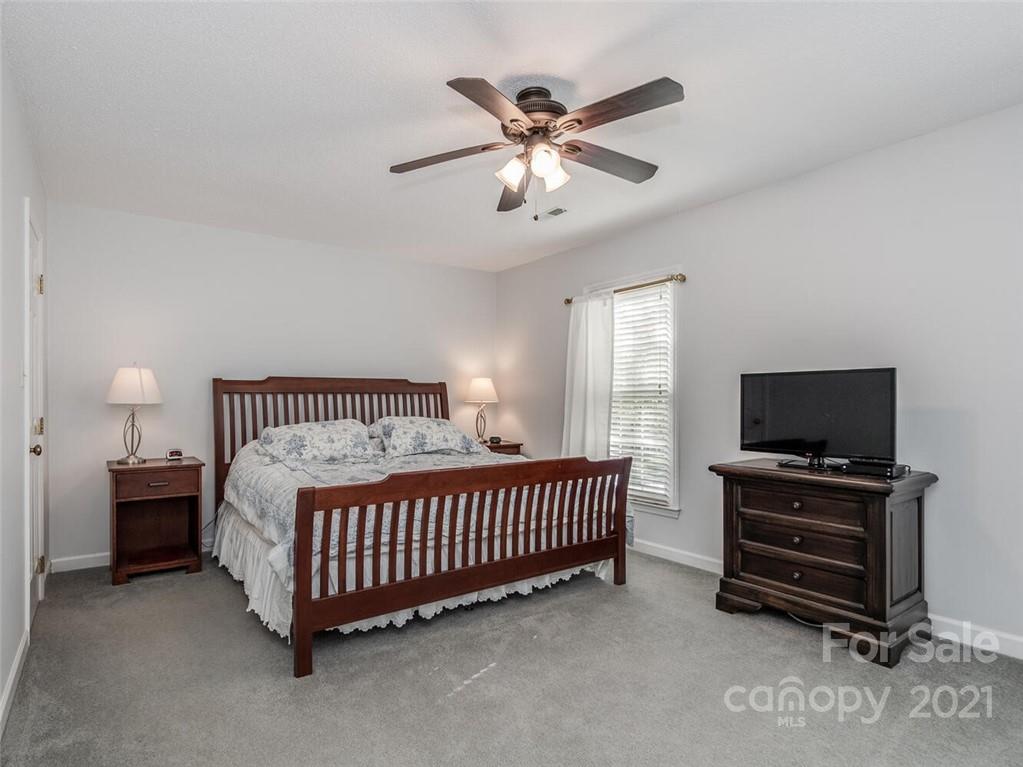 4312 Truscott Road Charlotte, NC 28226 - Photo 17 of 31 a bedroom with a bed and a chandelier