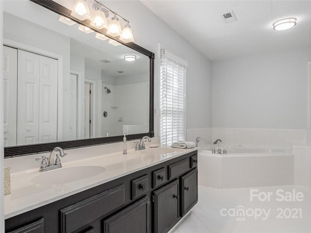 4312 Truscott Road Charlotte, NC 28226 - Photo 19 of 31 a bathroom with a double vanity sink a mirror and a bathtub