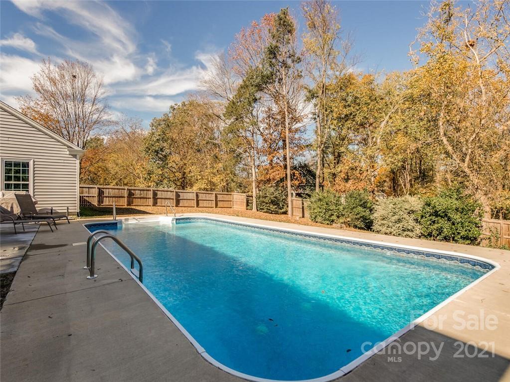 4312 Truscott Road Charlotte, NC 28226 - Photo 28 of 31 a view of a swimming pool with lawn chairs and a fire pit