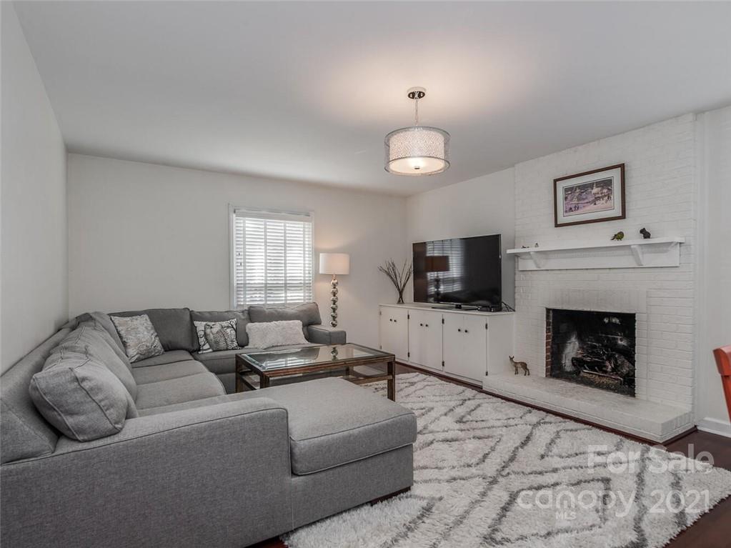 4312 Truscott Road Charlotte, NC 28226 - Photo 6 of 31 a living room with furniture a flat screen tv and a fireplace