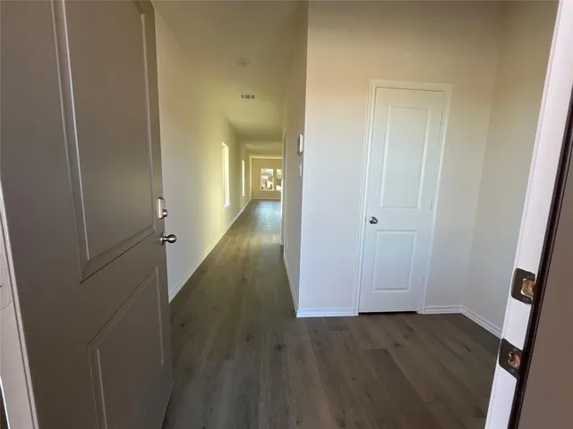 a view of a hallway with wooden floor