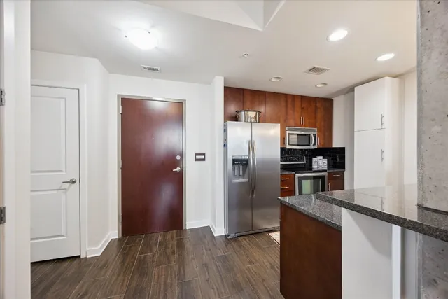 a kitchen with stainless steel appliances granite countertop a refrigerator and a sink