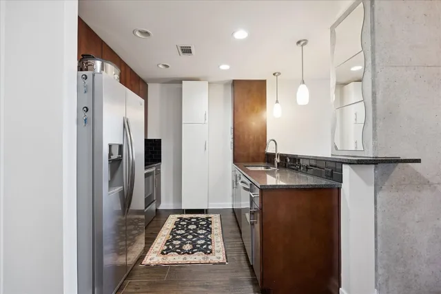 a kitchen with stainless steel appliances granite countertop a refrigerator and a stove