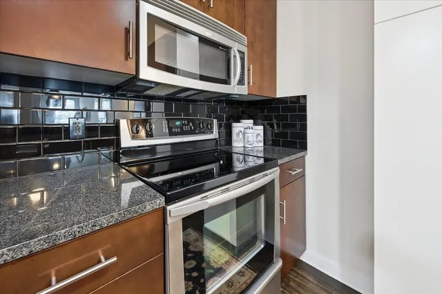 a kitchen with granite countertop a stove and a microwave