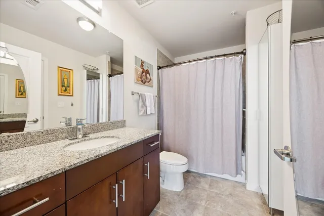 a bathroom with a granite countertop sink toilet and shower