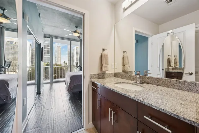 a en suite bathroom with a granite countertop sink and a mirror