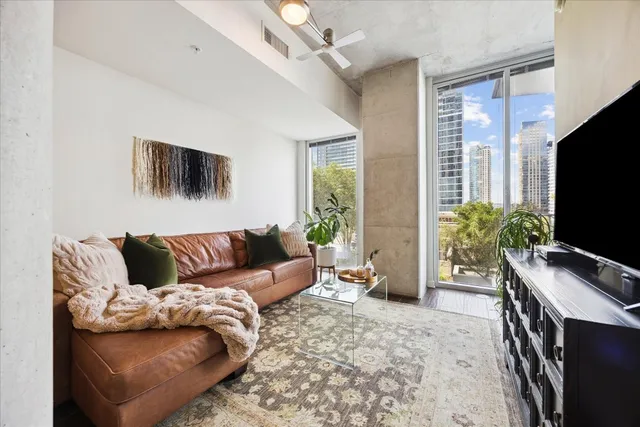 a living room with furniture a flat screen tv and a window