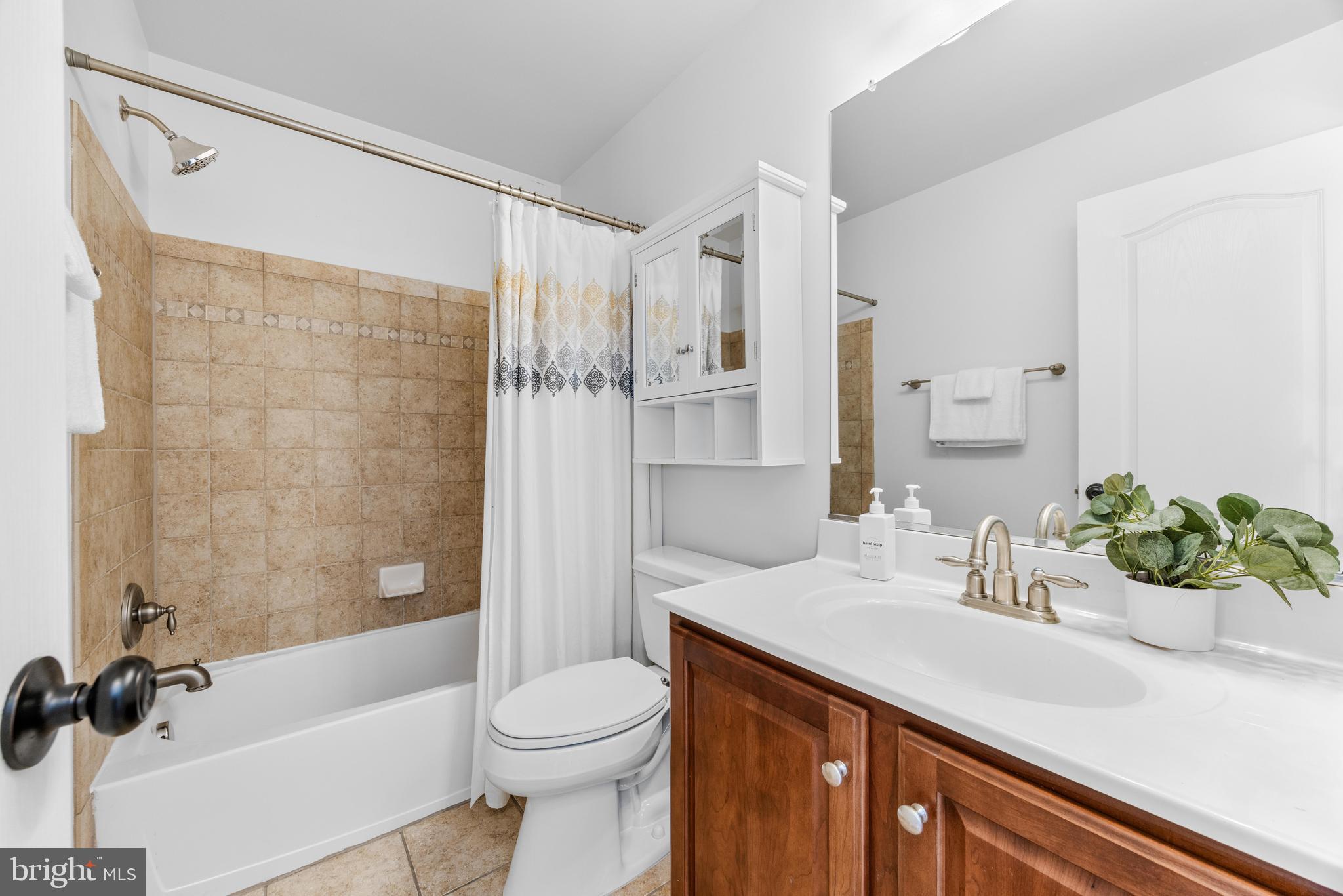 1436 Steuart Street Baltimore, MD 21230 - Photo 47 of 56 a bathroom with a granite countertop sink a toilet a mirror a bathtub and shower