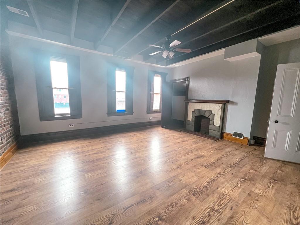 2414 East Carson Street, Unit 2 Pittsburgh, PA 15203 - Photo 4 of 15 an empty room with wooden floor fireplace and windows