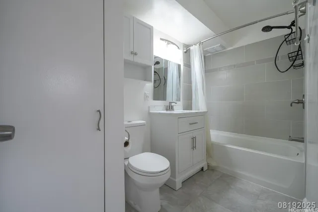 a bathroom with a granite countertop toilet sink and mirror
