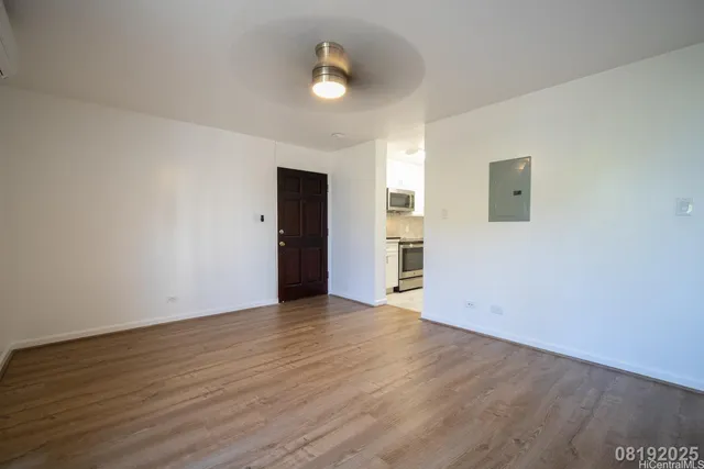 an empty room with wooden floor and door