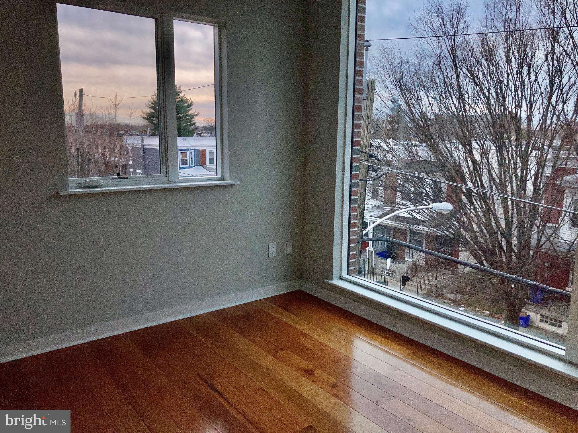 5358 Addison Street, Unit 2 Philadelphia, PA 19143 - Photo 6 of 13 a view of a room with wooden floor and large window