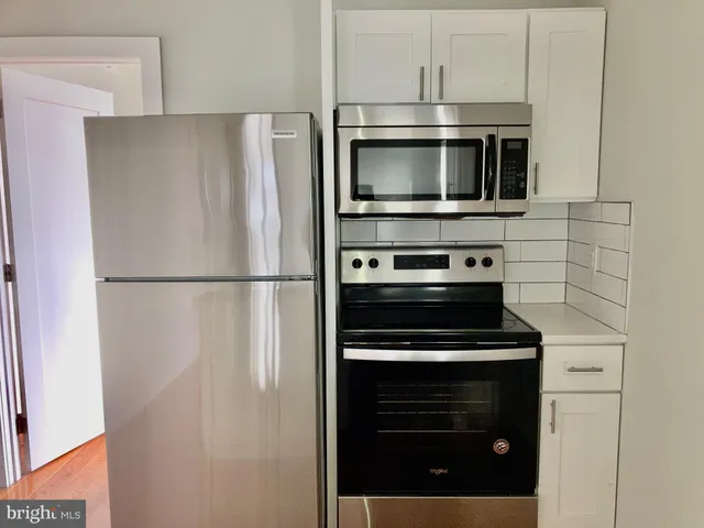 a kitchen with stainless steel appliances a refrigerator stove and microwave