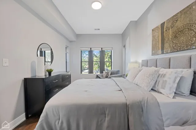 a bedroom with a bed and a large window